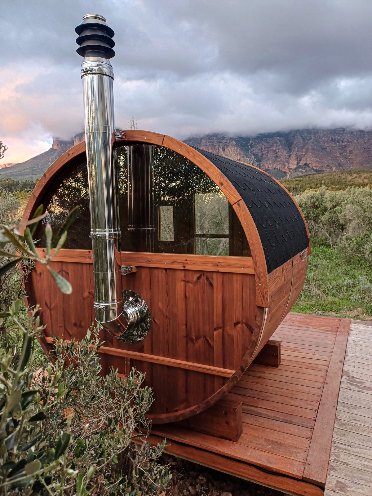 A BANYA sauna lit at night, a chair pulled up outside